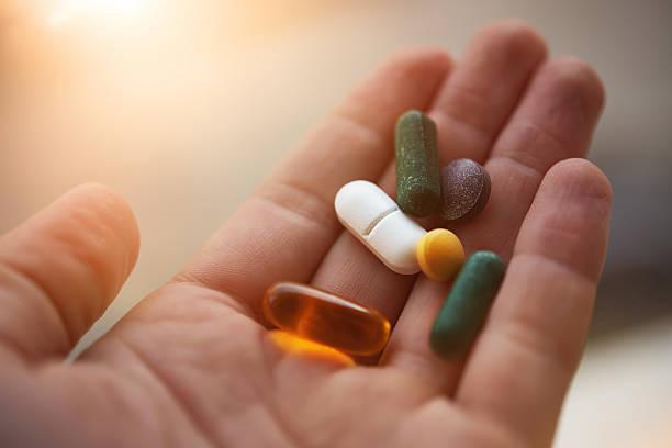 prepared to take my nutritional supplements man hand holding his nutritional supplemets, healthy lifestyle background. taking more capsules stock pictures, royalty-free photos & images
