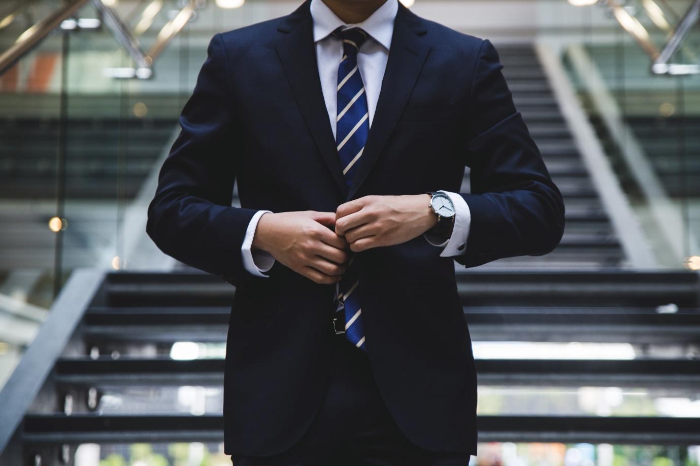 A person in a suit and tie

Description automatically generated with medium confidence
