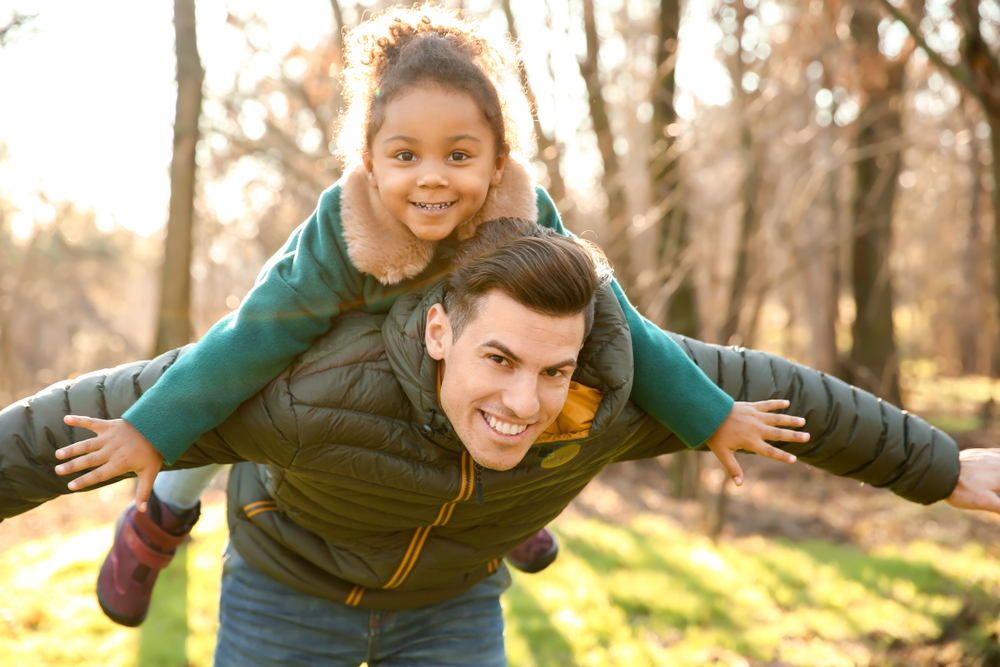 kid on father's shoulder in the fall